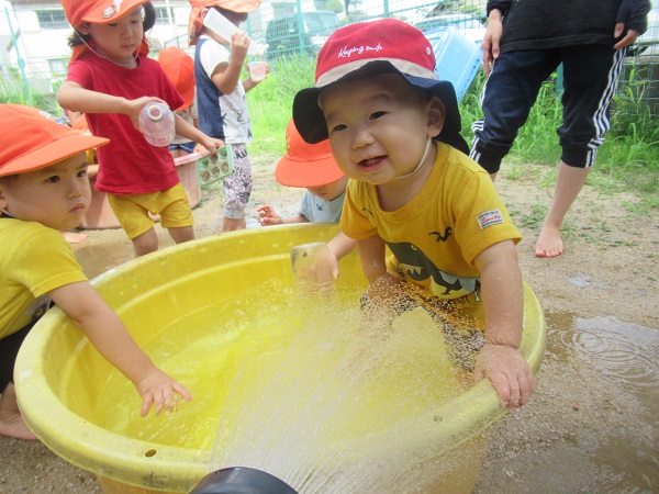 男の子がたらいに入って遊んでいる