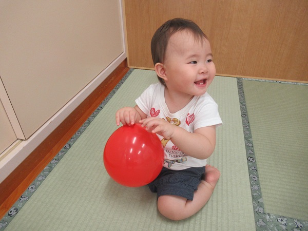 風船を持って笑う