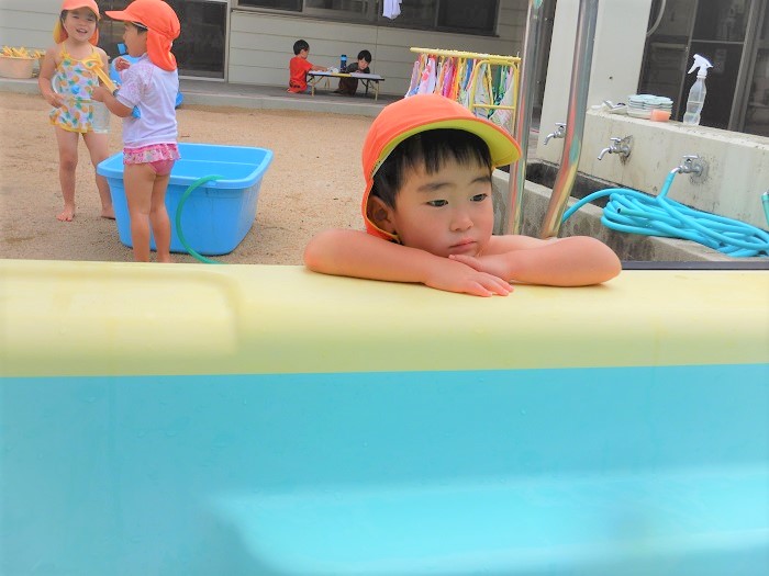 待ち遠しくプールの様子を見る男の子