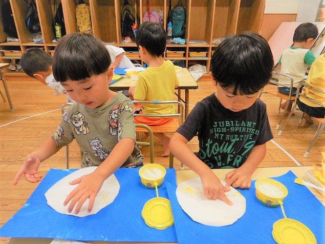 糊で紙を貼る子ども