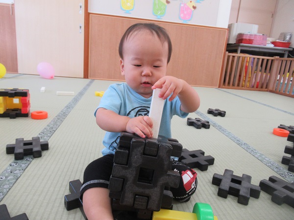 ブロックの穴にブロックを入れようとする男の子