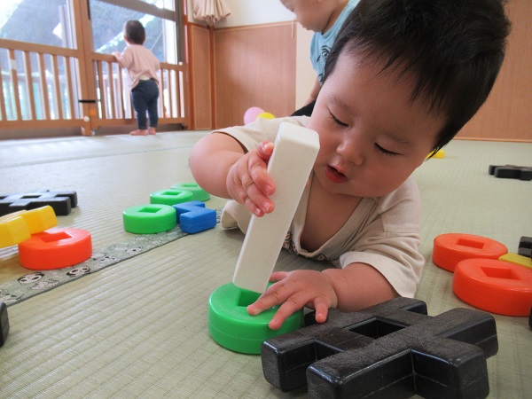 ブロックの穴にブロックを入れようとする男の子