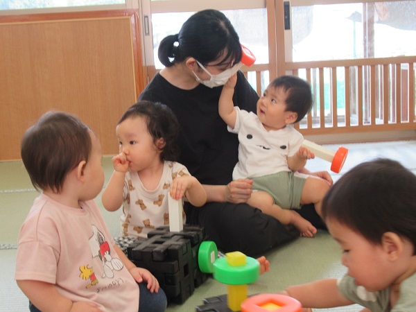 保育者に出来たおもちゃを見せてくれる男の子