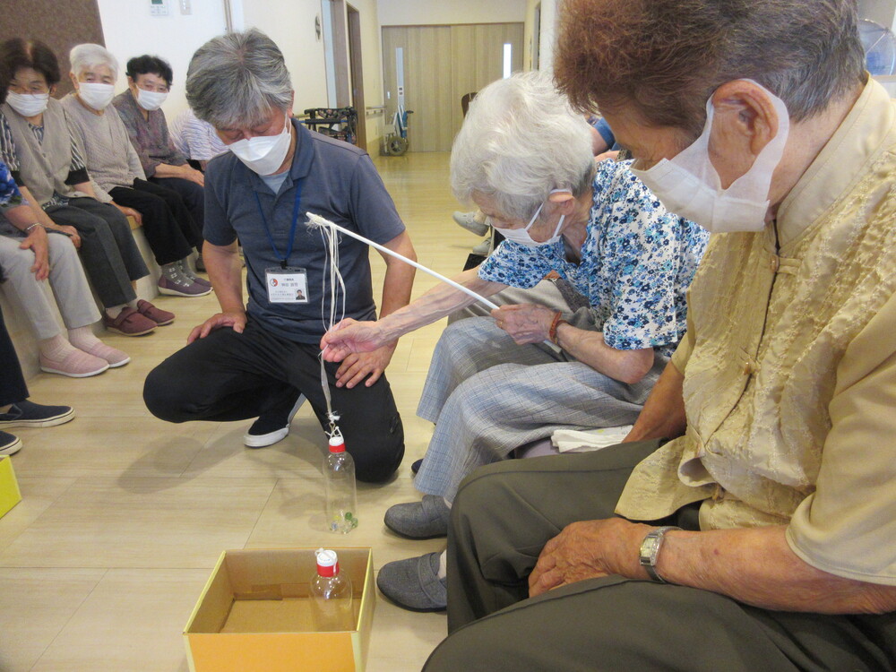 ペットボトルを釣り上げて箱に入れる様子