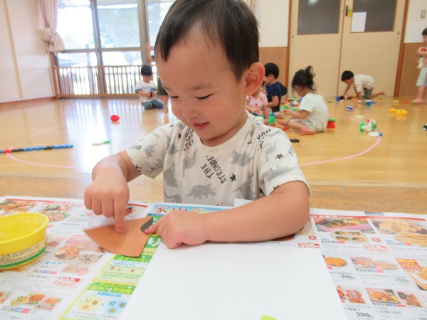画用紙に糊を塗っている男の子
