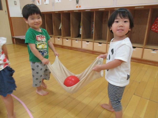 タオルに乗せてボールを運ぶ男の子