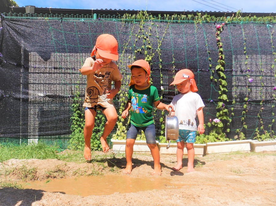 水たまりで遊ぶ子ども