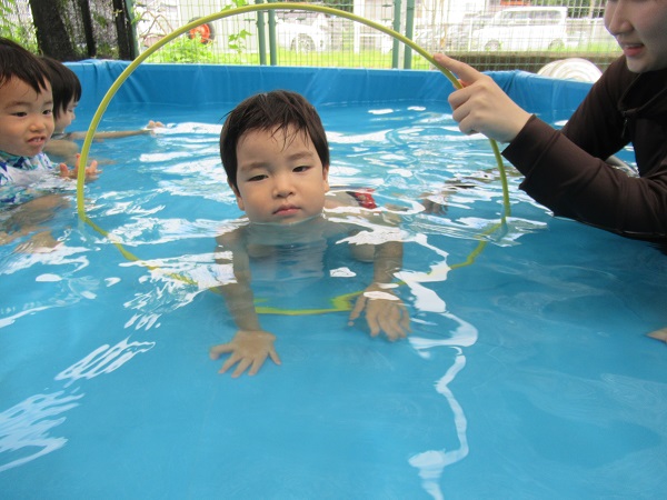 フラフープをくぐる男の子