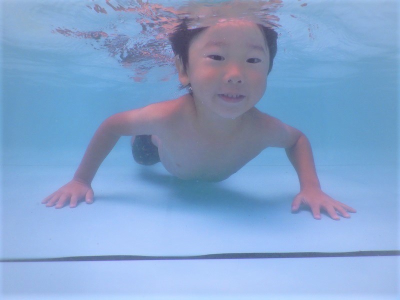 プールで泳ぐ男の子