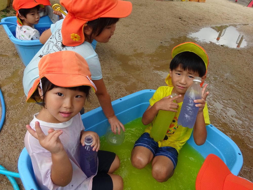 タライの中に入る子どもたち