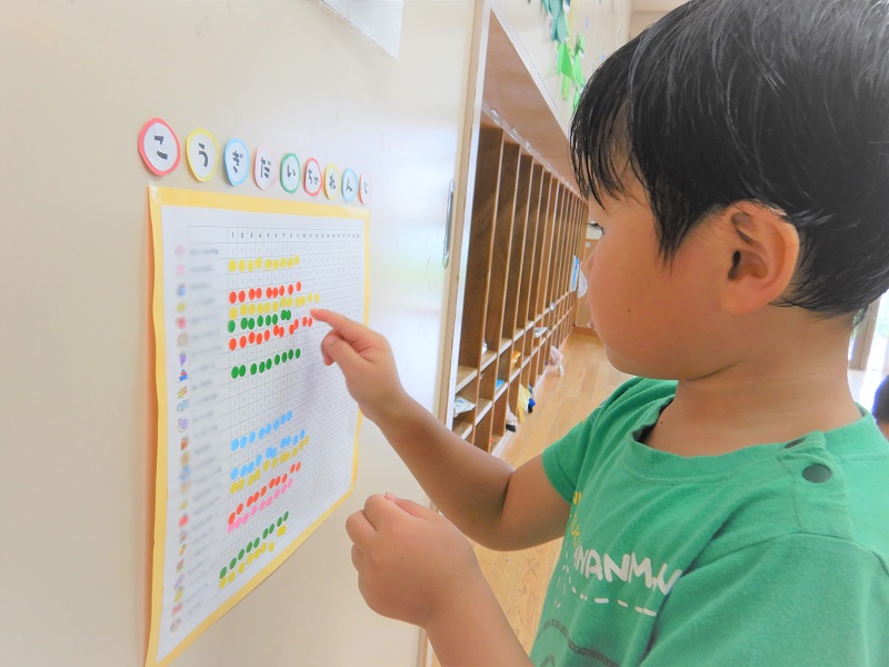 表にシールを貼る男の子