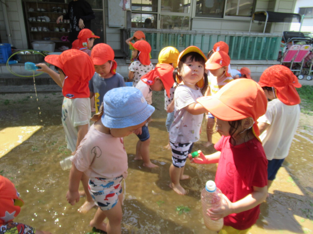 水たまりで遊ぶ子どもたち