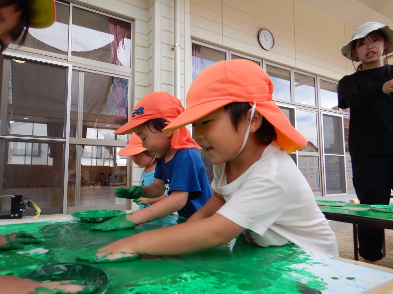 画用紙を塗る子どもたち