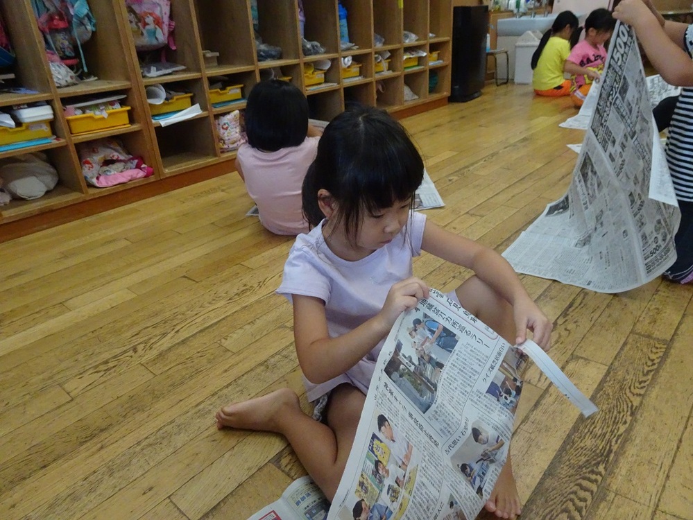 新聞紙をちぎる女の子