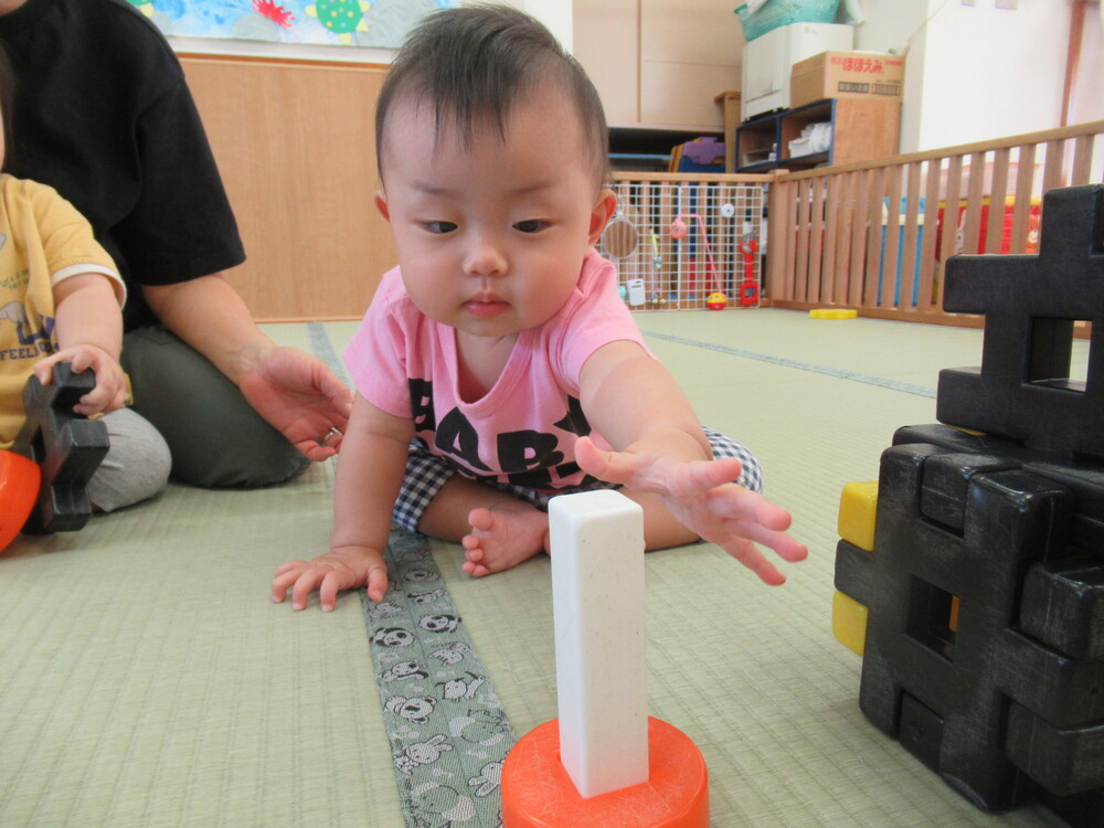 ブロックに手を伸ばす女の子