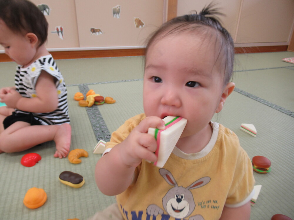 男の子がサンドウィッチの玩具を持っている