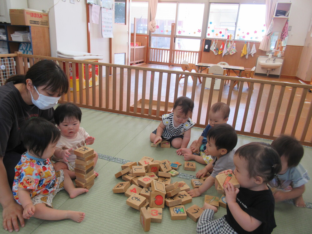 積み木の周りに集まる子ども達