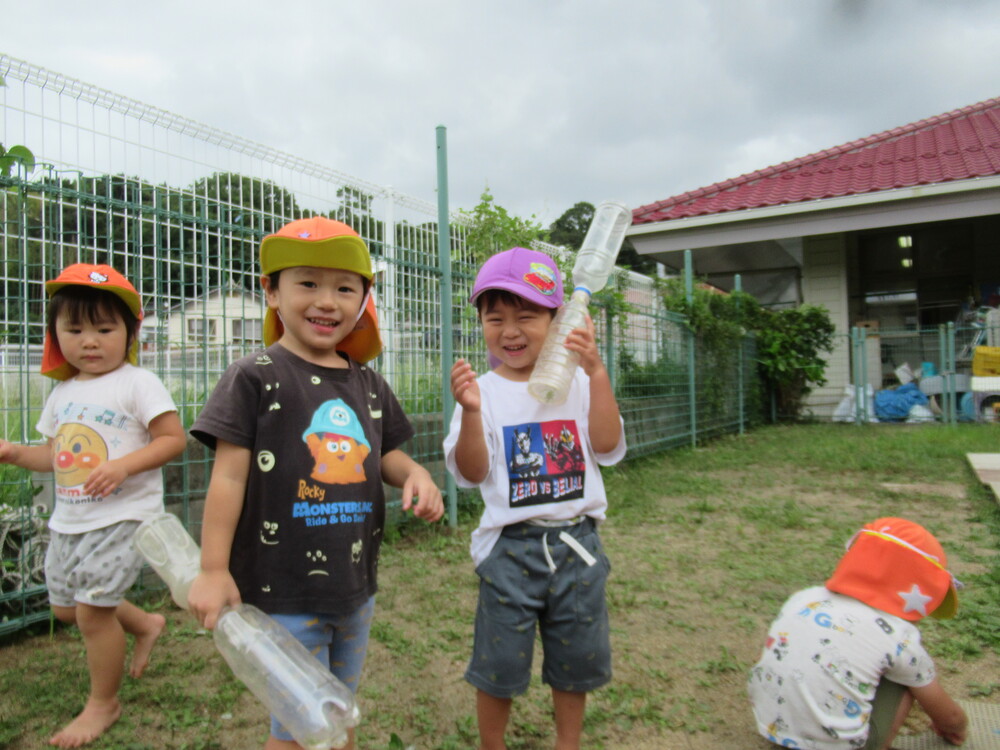 つなげたペットボトルを持っている男の子2人