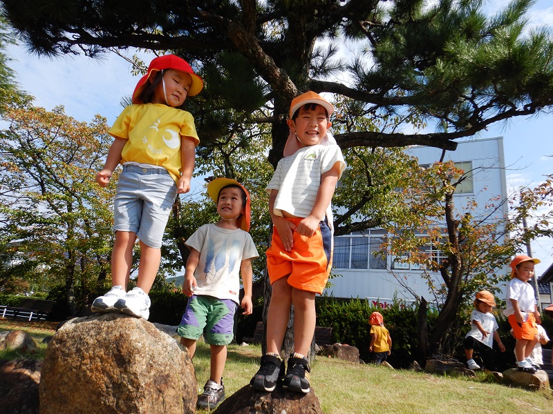 石の上でポーズを決める子どもたち