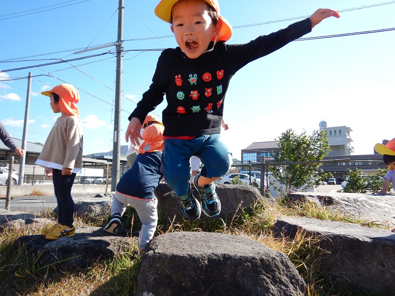 石の上からジャンプをする男の子