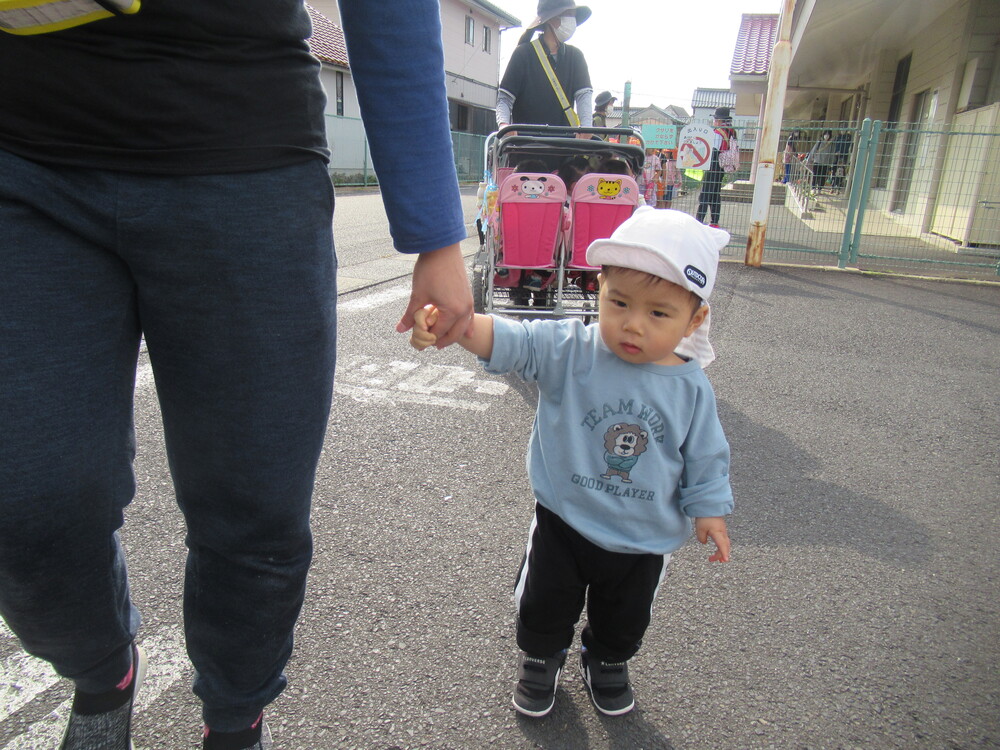 保育者と手を繋いで歩く子ども達