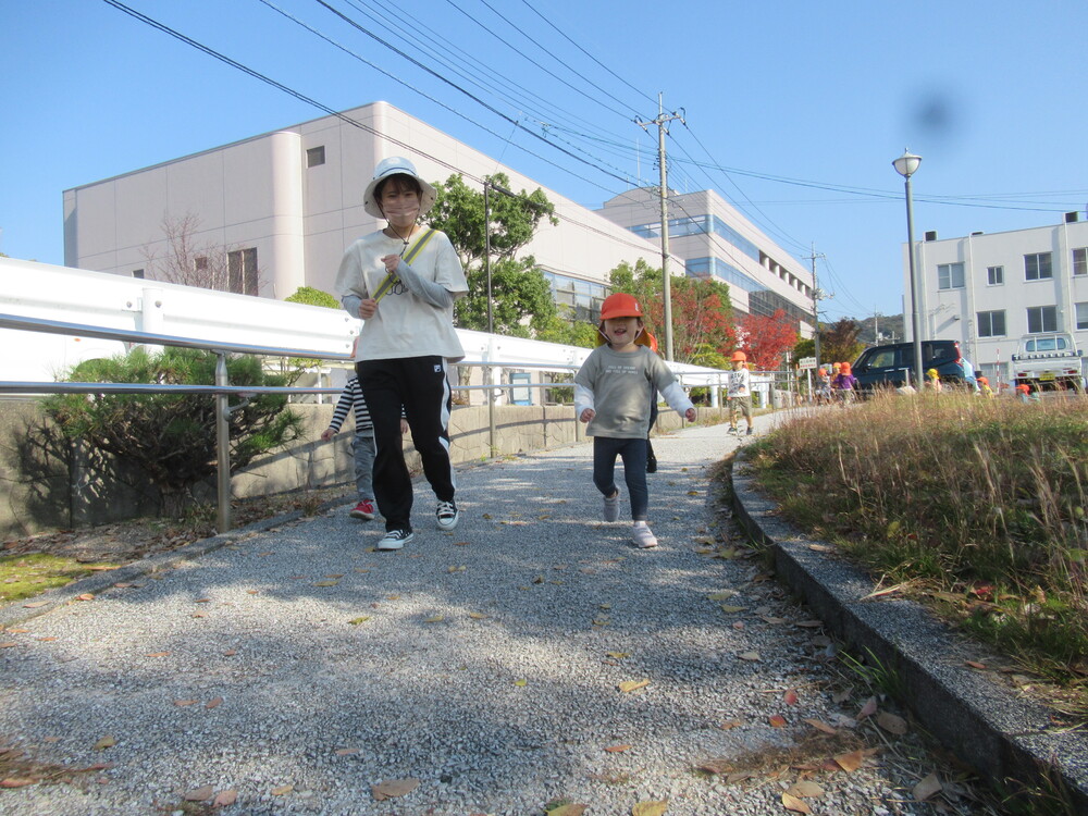 保育者と走る子どもたち