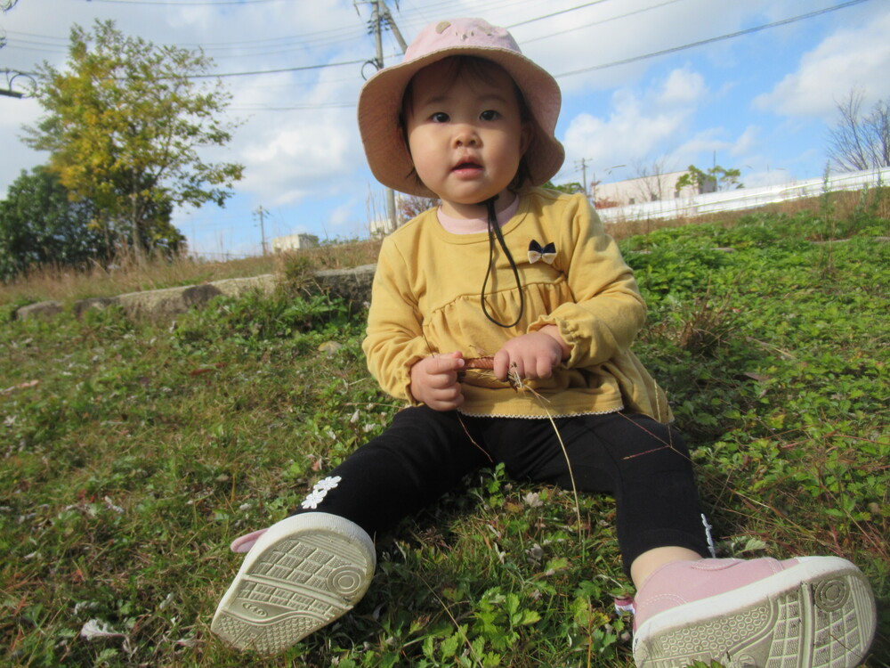 芝生で日向ぼっこをする子ども