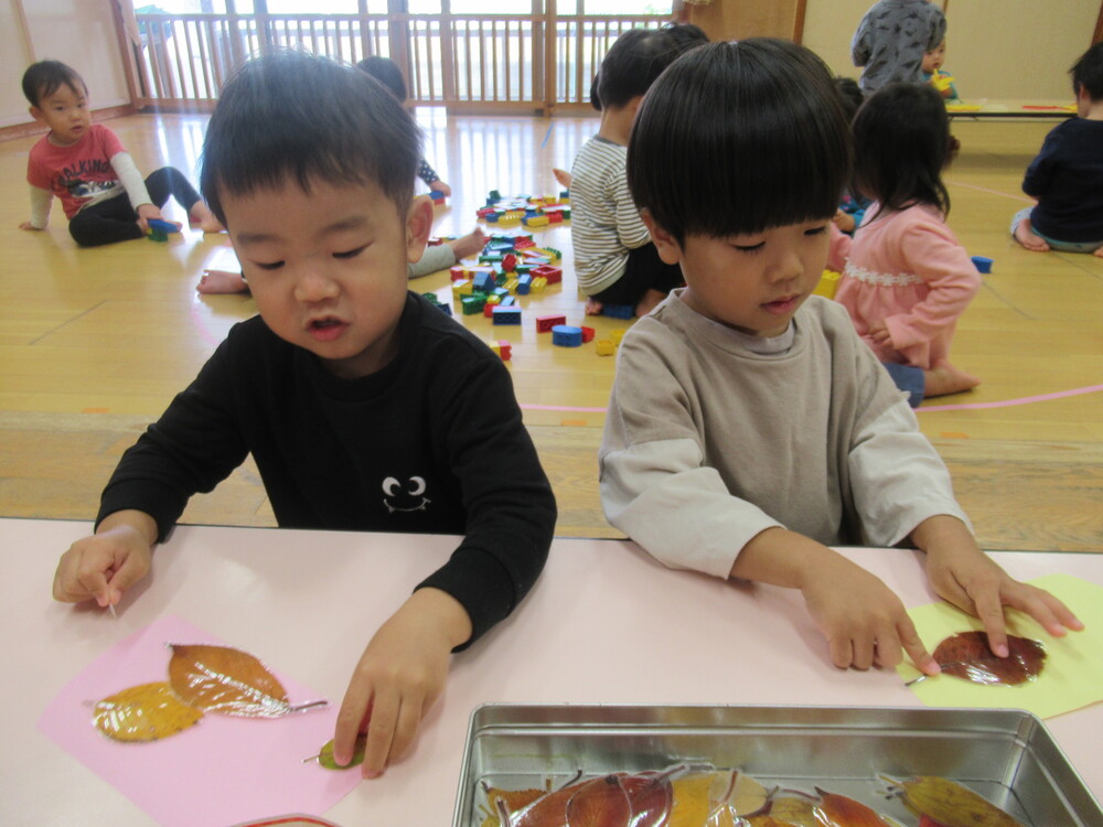 落ち葉を貼っている男の子たち