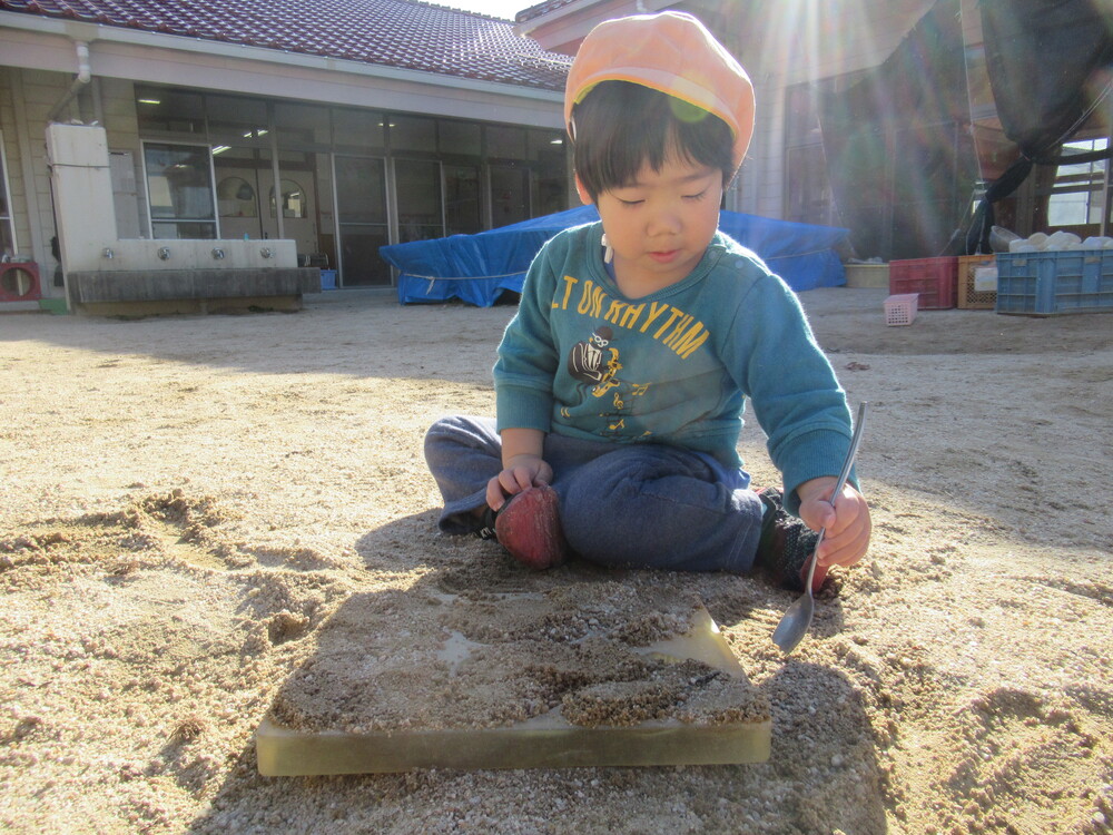 砂を使って遊ぶ男の子