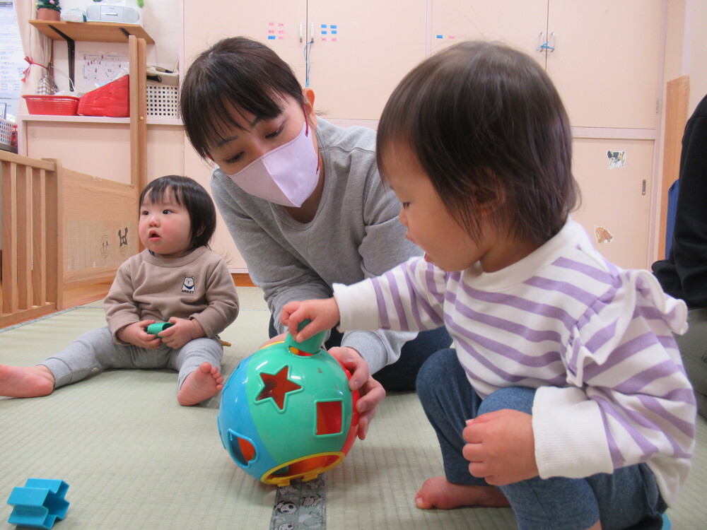 女の子と保育者が遊んでいる