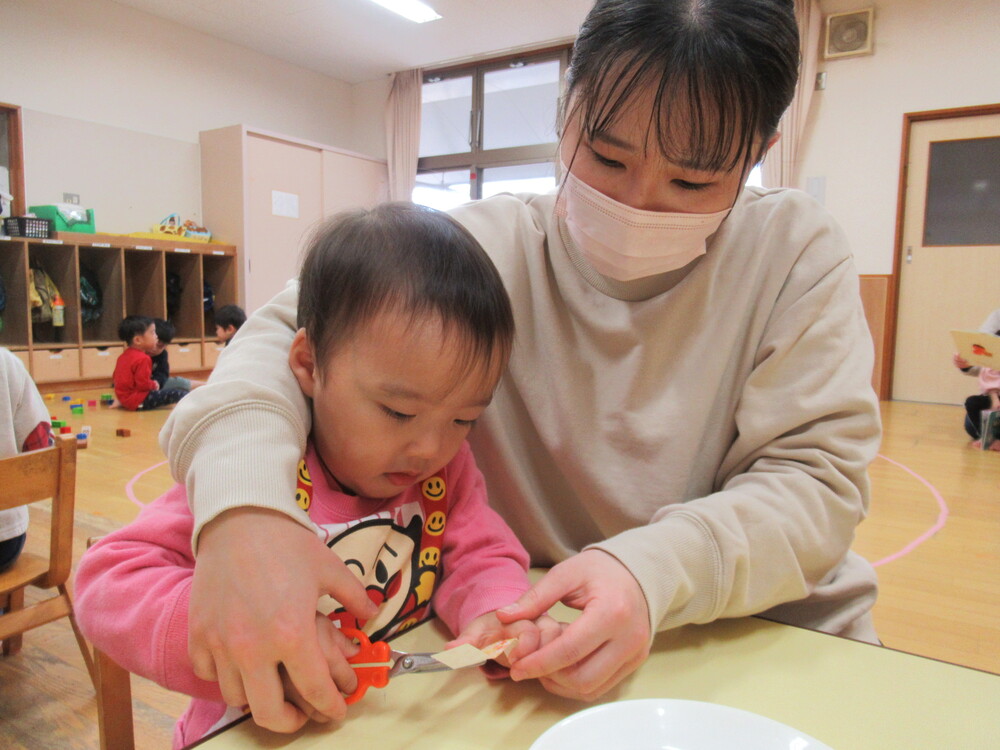 保育者とはさみを使っている男の子