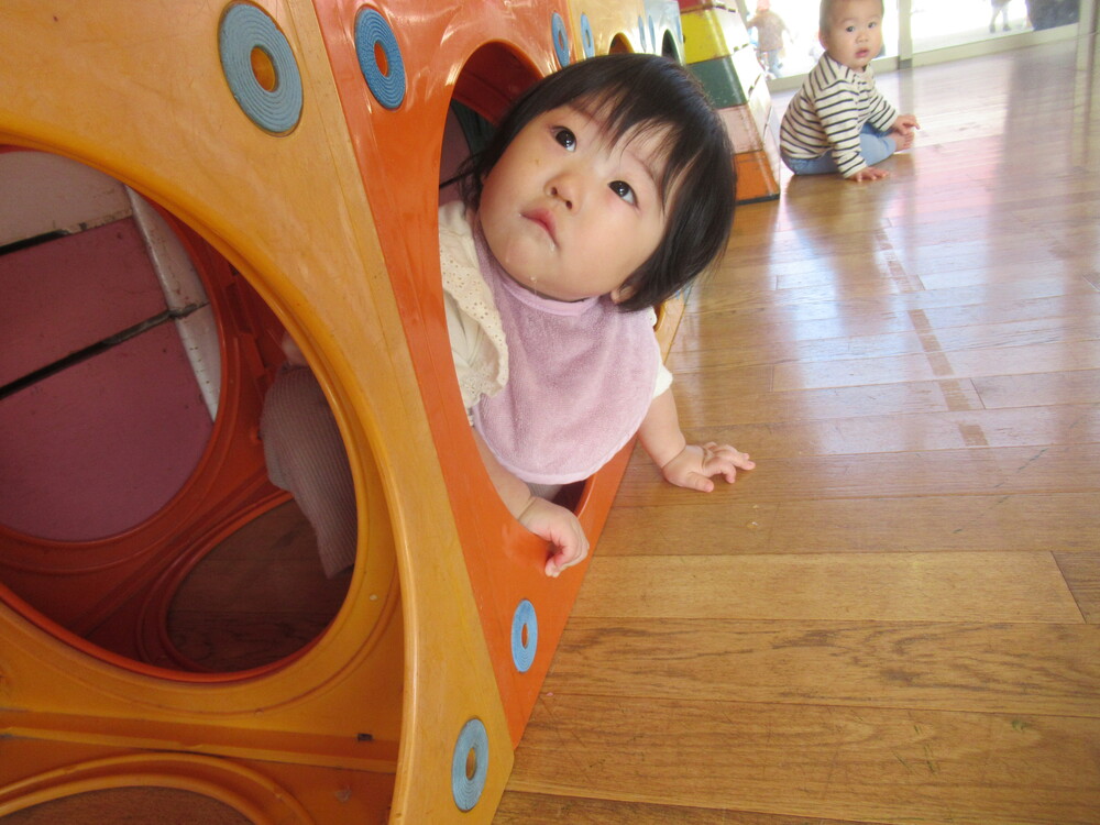 子どもがカラーボックスから顔を出している