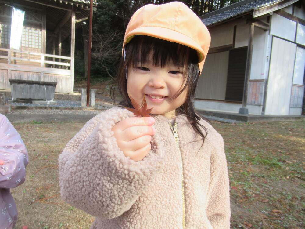 もみじの葉っぱを持っている女の子
