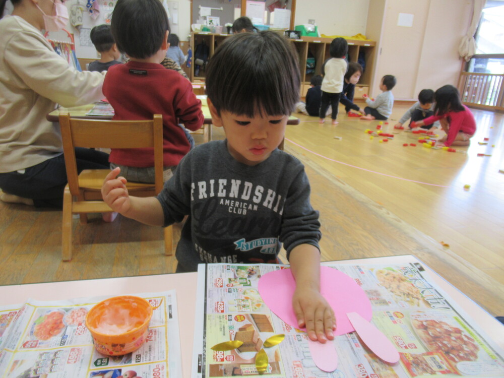 糊でおり紙を貼っている