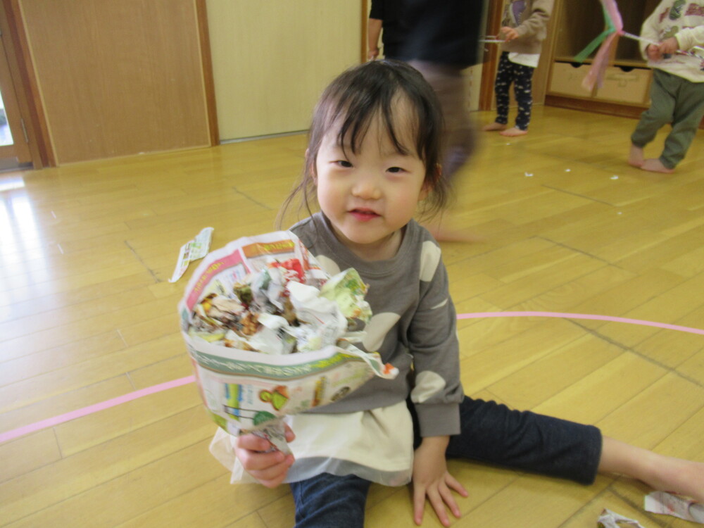 紙で作った花束を見せている