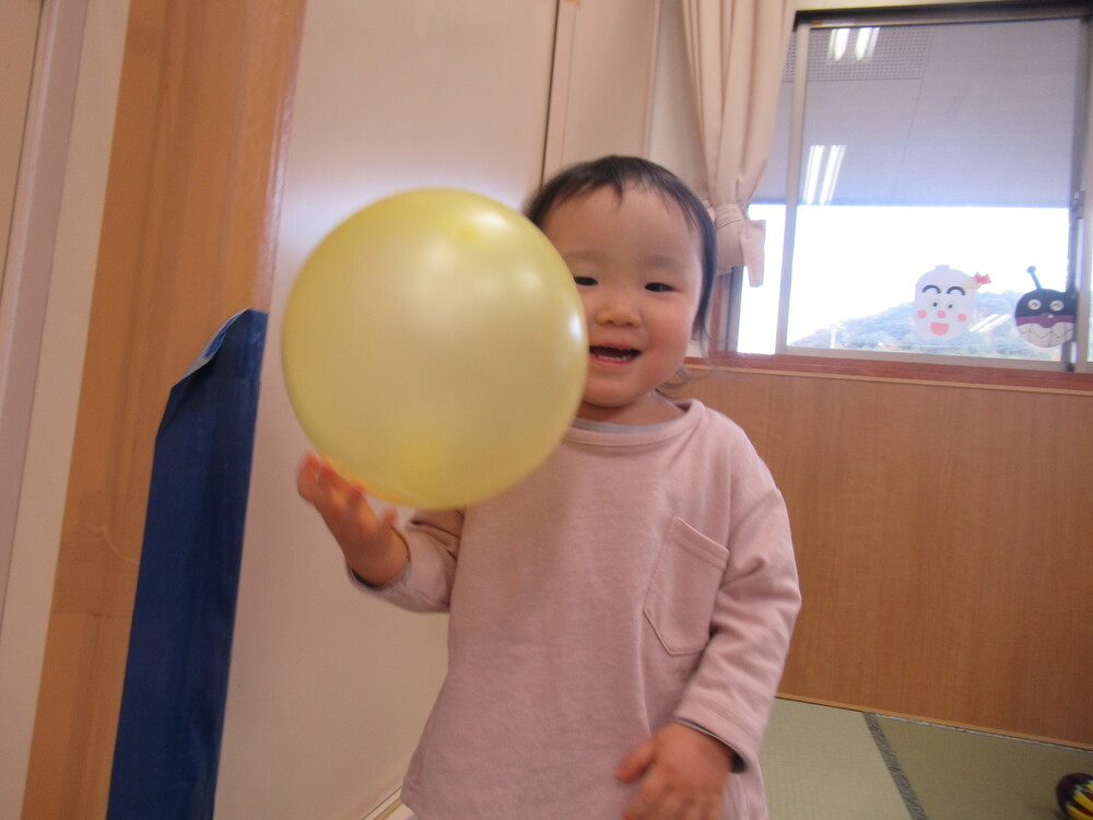 顔に風船をくっつけて遊ぶ子ども