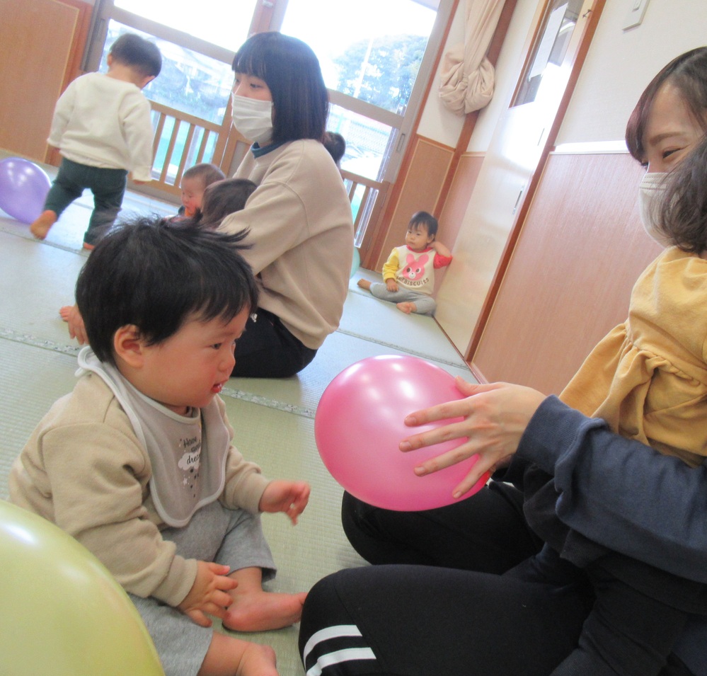 保育者に風船を持って来てくれる子ども