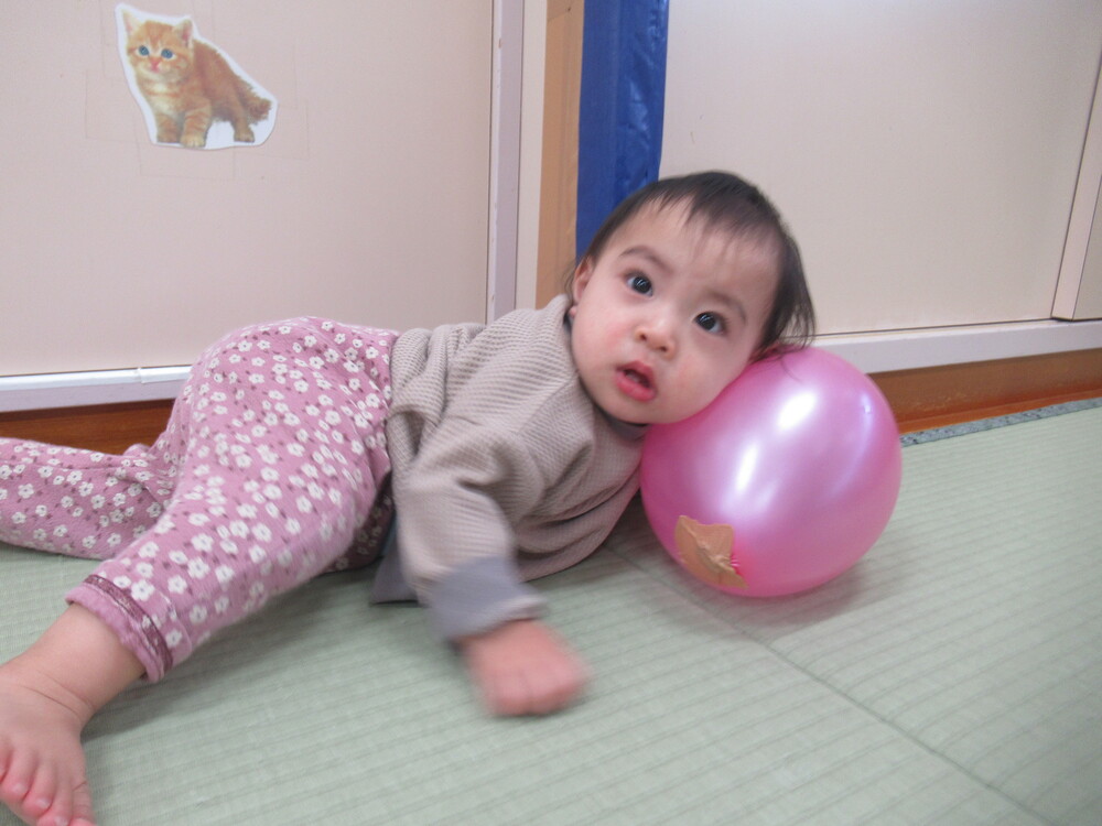 風船を枕のようにして遊ぶ子ども