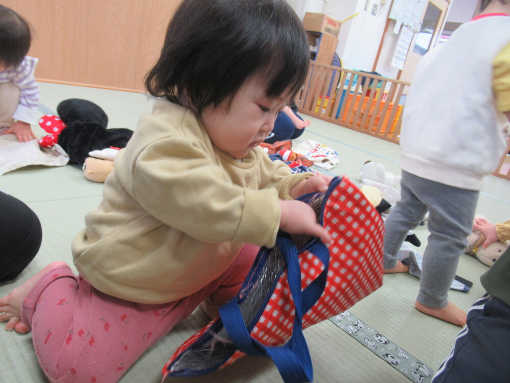 女の子がカバンにぬいぐるみを入れている