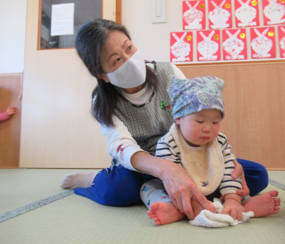 保育者と一緒に掃除をする子ども