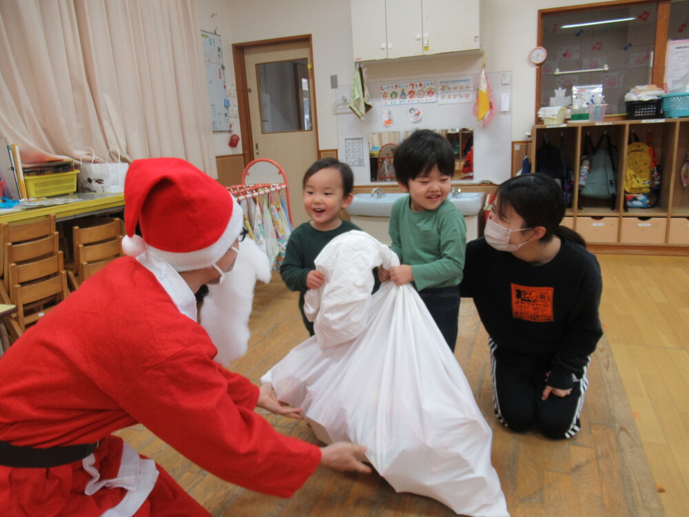 サンタさんからプレゼントをもらう子どもたち