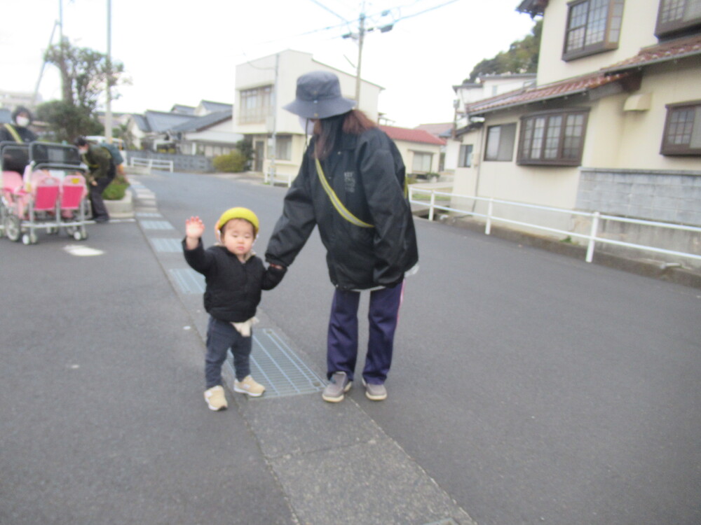 手を挙げて道を渡っている