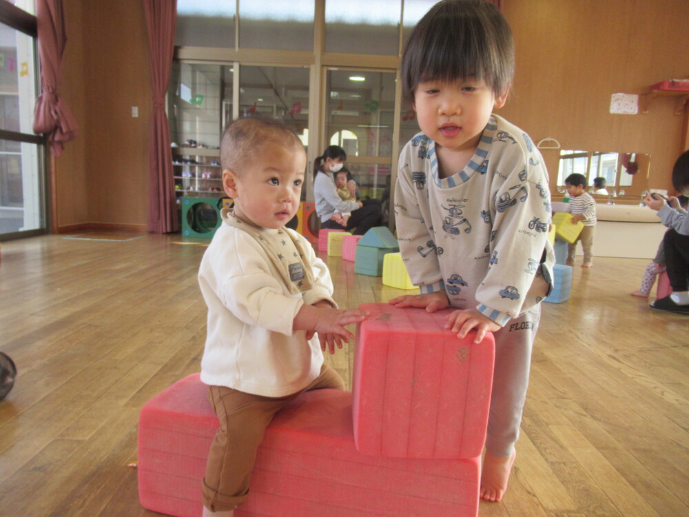 お友だちと太鼓のようにして遊ぶ子ども