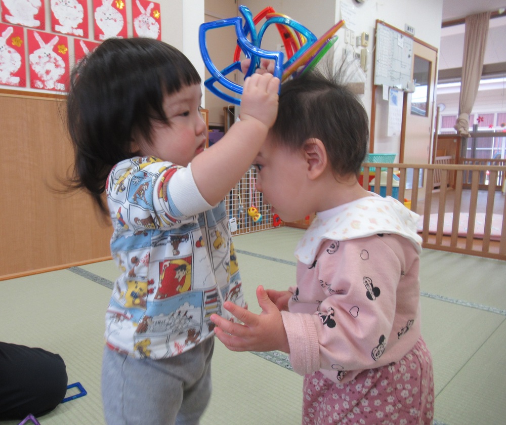 帽子をお友だちに被せてあげる子ども達