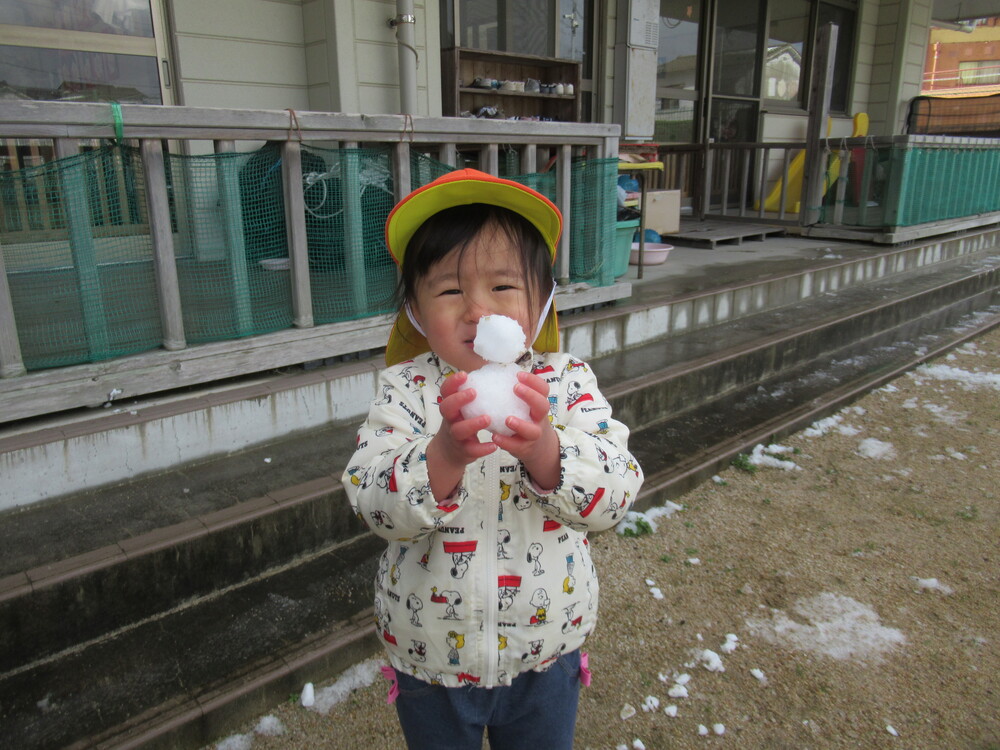 小さな雪だるまを持っている女の子