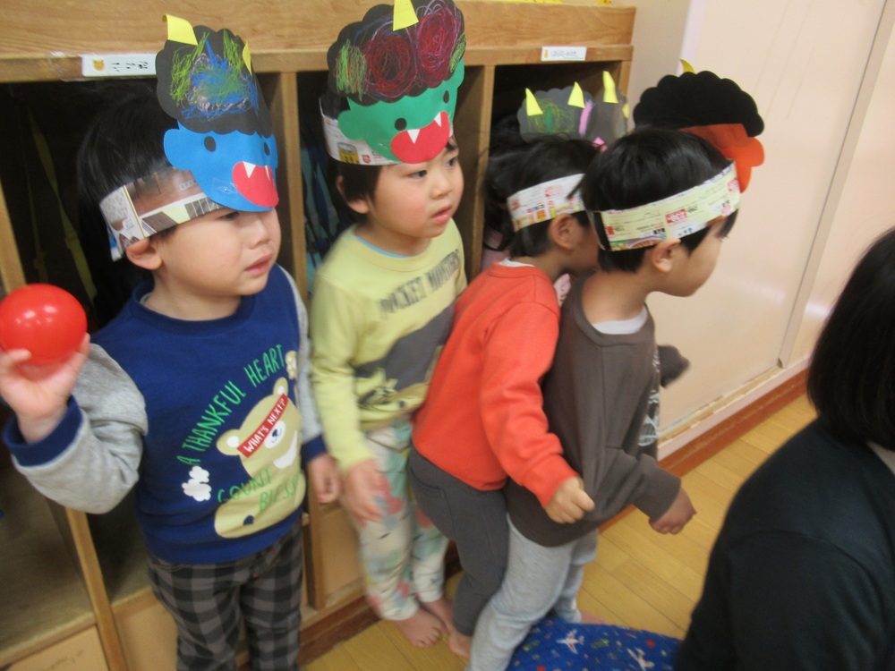 保育者の後ろに隠れている子どもたち