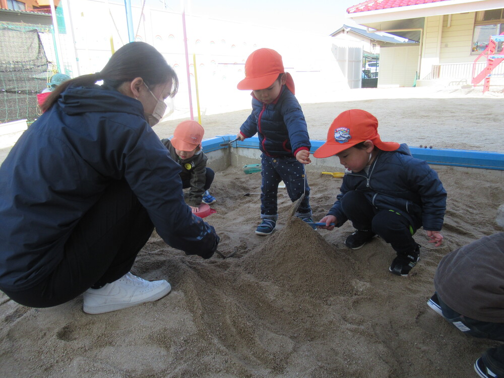 砂場で山を作って遊んでいる
