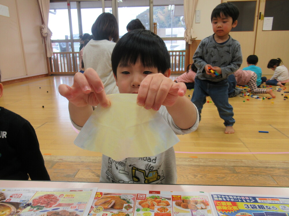 色付けしたコーヒーフィルターを持っている男の子
