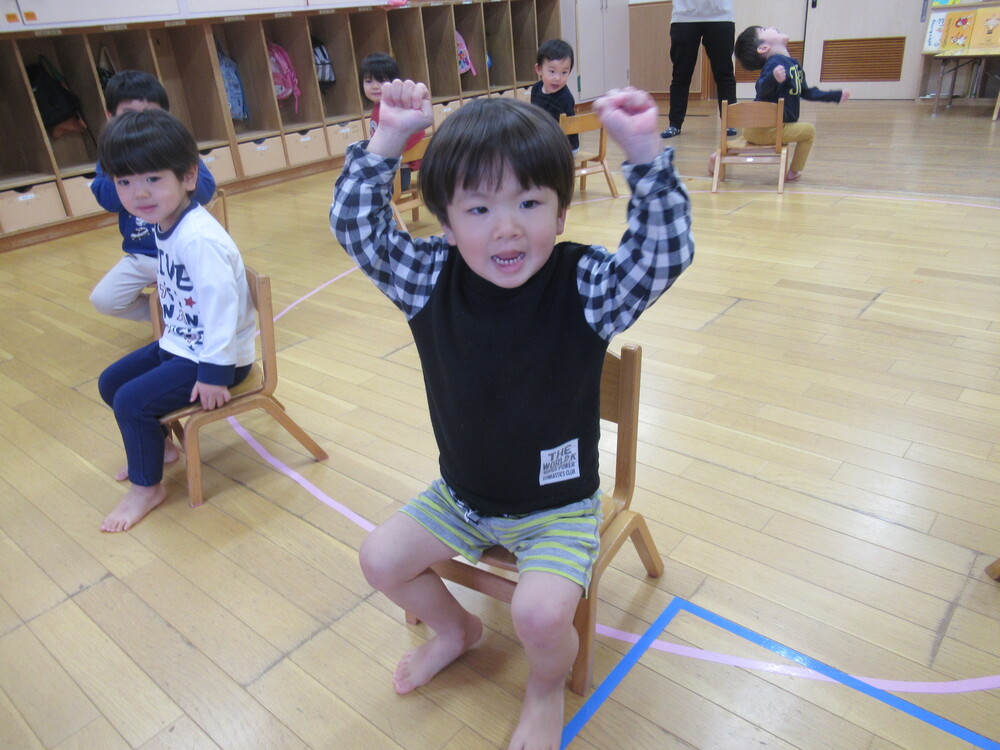 椅子に座れて喜んでいる男の子