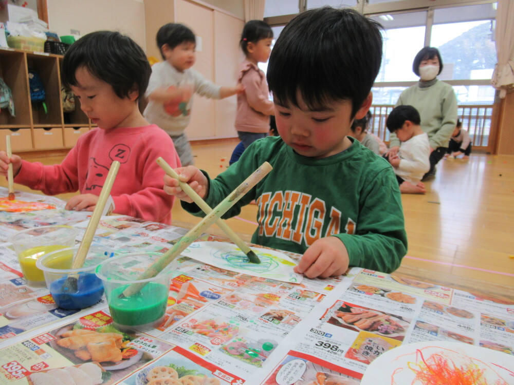 絵の具で色を塗っている子どもたち